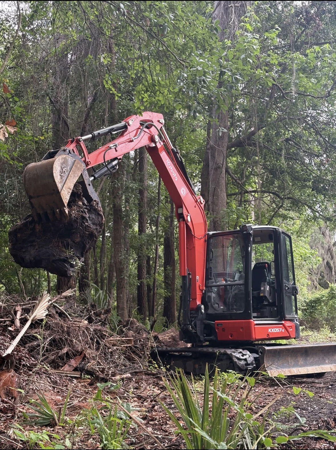 Kubota excavator clearing land